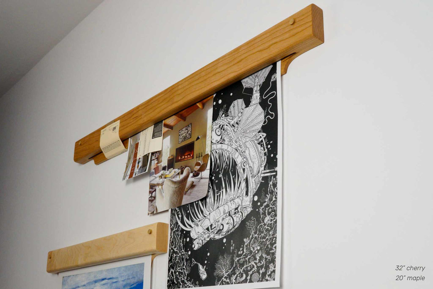The Gravity Bar, by Biglow Woodcraft; a wooden holder for papers, pictures and images. Two wooden bar installed on a white wall, holding photos. Hardwood Maple and Cherry