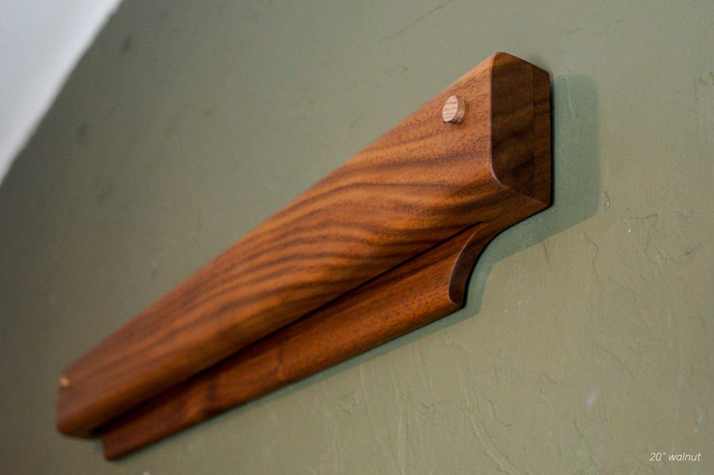 The Gravity Bar, by Biglow Woodcraft; a wooden holder for papers, pictures and images. Two wooden bar installed on a green wall. Hardwood Walnut