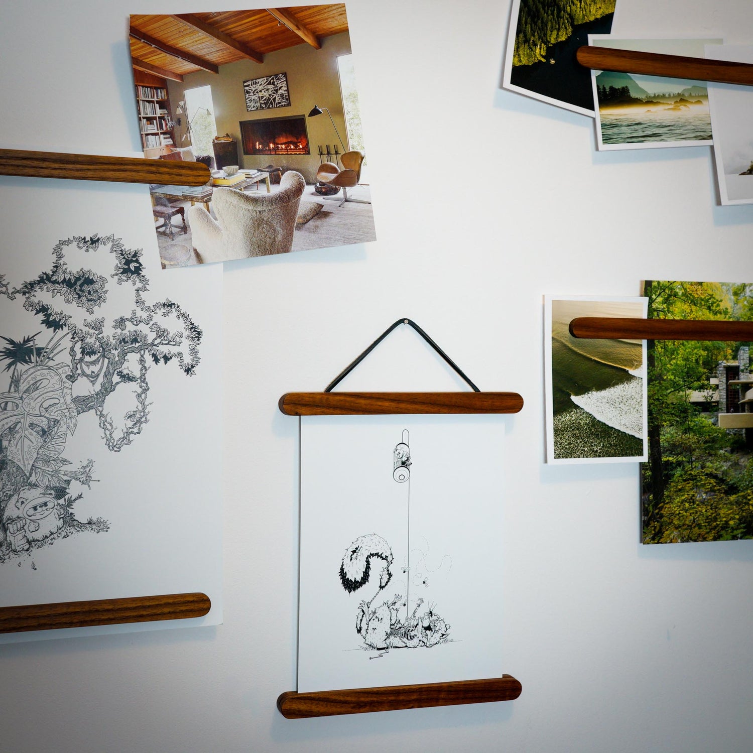The Magnet Sticks, by Biglow Woodcraft; a wooden support for papers, photographs and images. A set of magnet sticks with photographs installed on a white wall. Hardwood Roasted ash