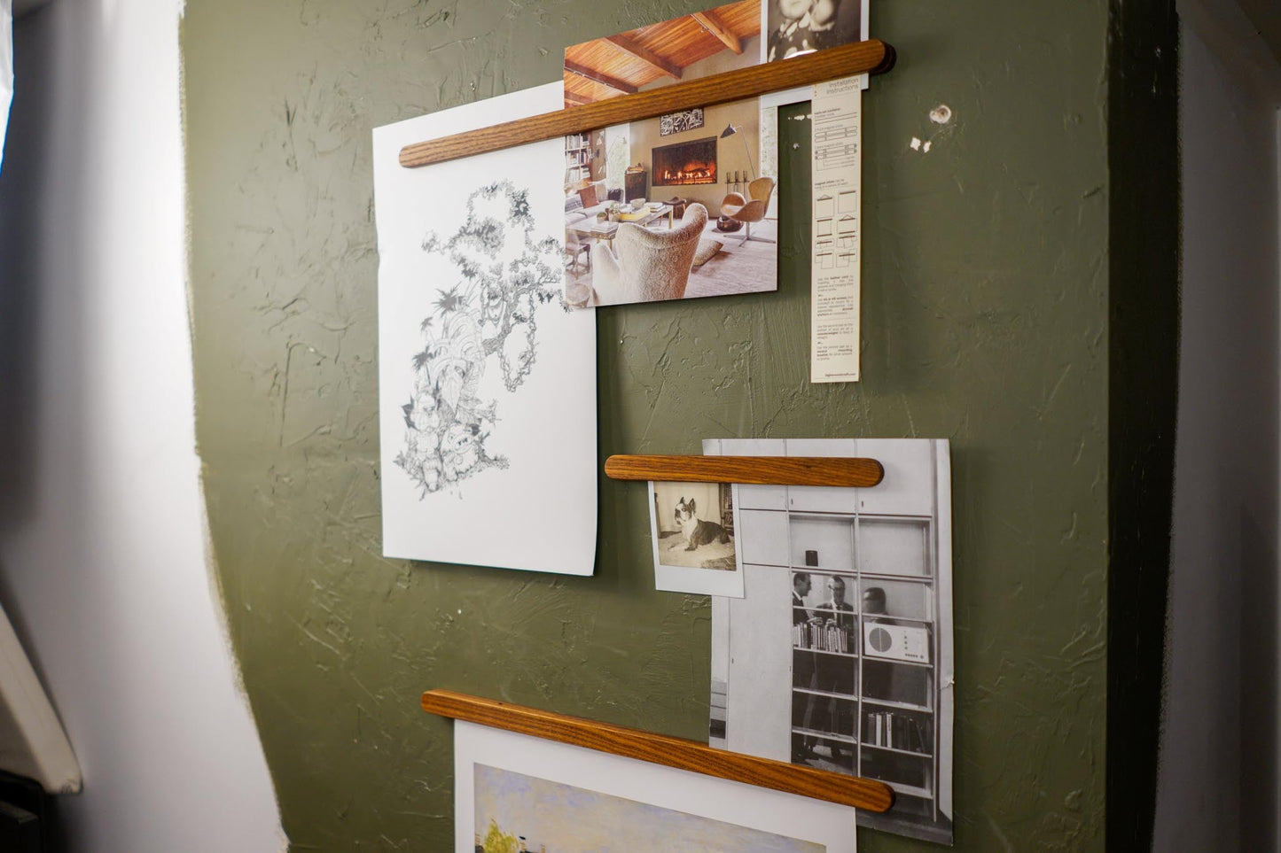  The Magnet Sticks, by Biglow Woodcraft; a wooden support for papers, photographs and images. A set of magnet sticks with photographs installed on a green wall. Hardwood Roasted ash