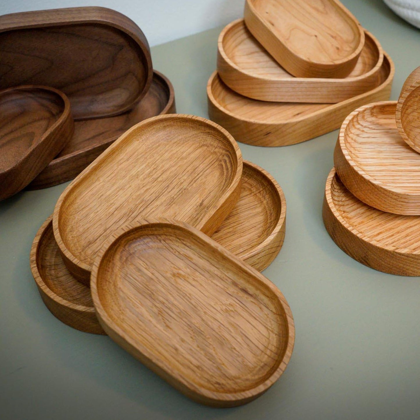 The Thing Spots, by Biglow Woodcraft; a wooden tray set for small objects. Various set of Thing spots on a green table. Hardwood White Oak